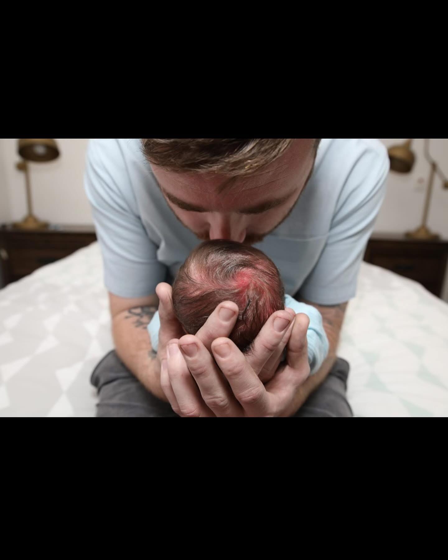 Baylee gently holding newborn Jasper in his hands