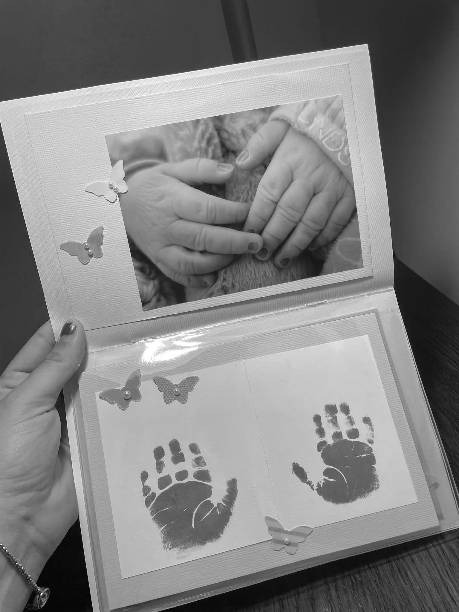 A keepsake album with a photograph of Jasper’s tiny hand held by his parents and prints of his hands